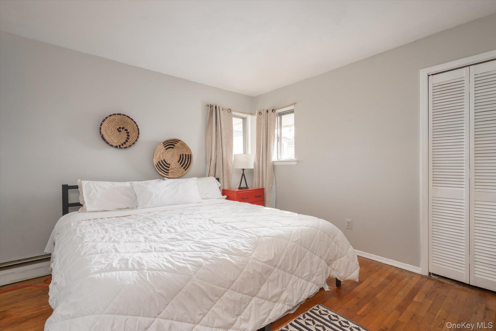 7 Stein Street Valley Stream, NY 11580 - Photo 12 of 27 Bedroom with wood finished floors, a closet, and a baseboard heating unit
