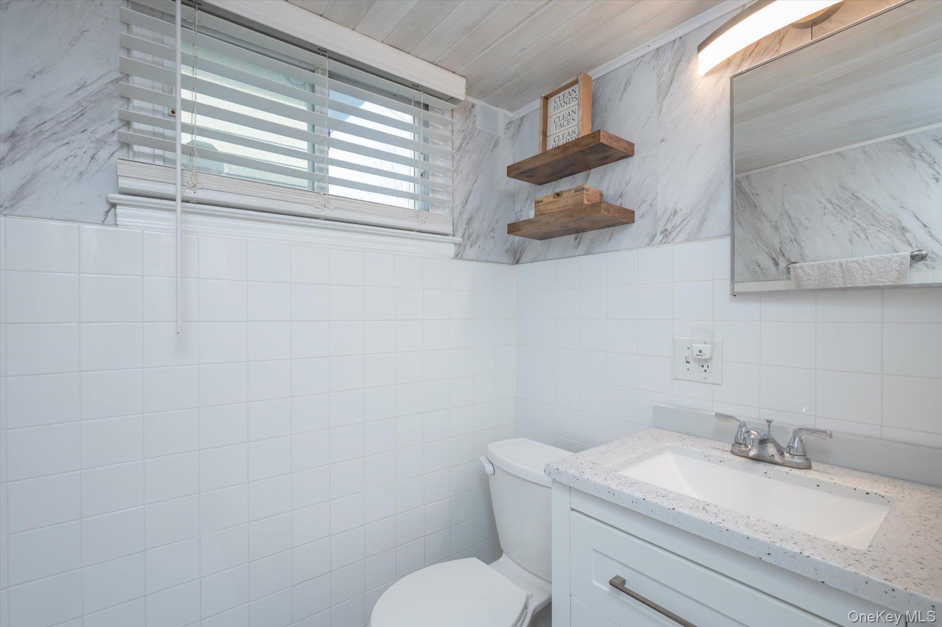 7 Stein Street Valley Stream, NY 11580 - Photo 16 of 27 Updated Bathroom featuring vanity, tile walls, and wood ceiling