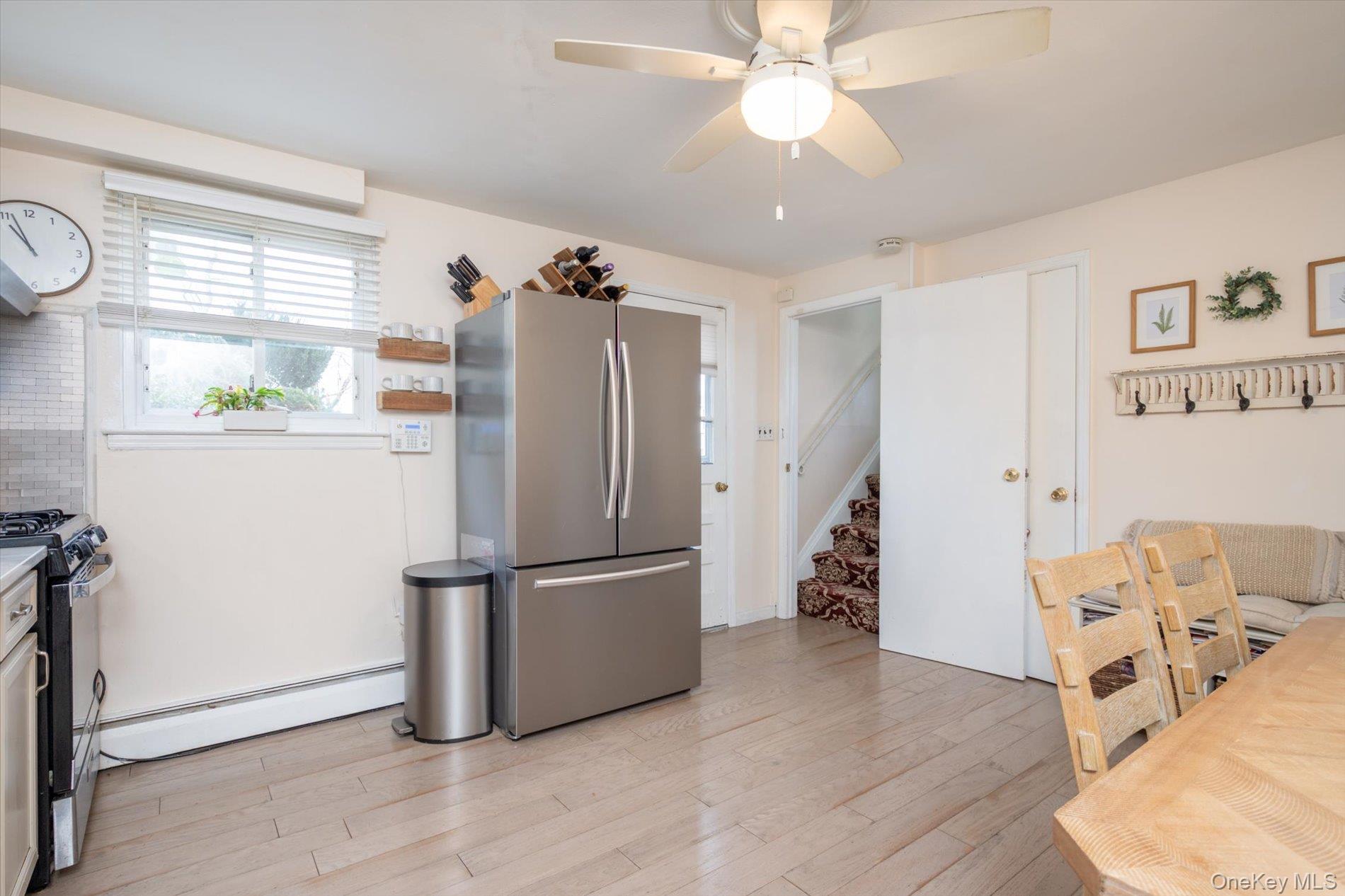 7 Stein Street Valley Stream, NY 11580 - Photo 21 of 27 Kitchen with freestanding refrigerator, gas stove, a baseboard radiator, light wood-type flooring, and a ceiling fan