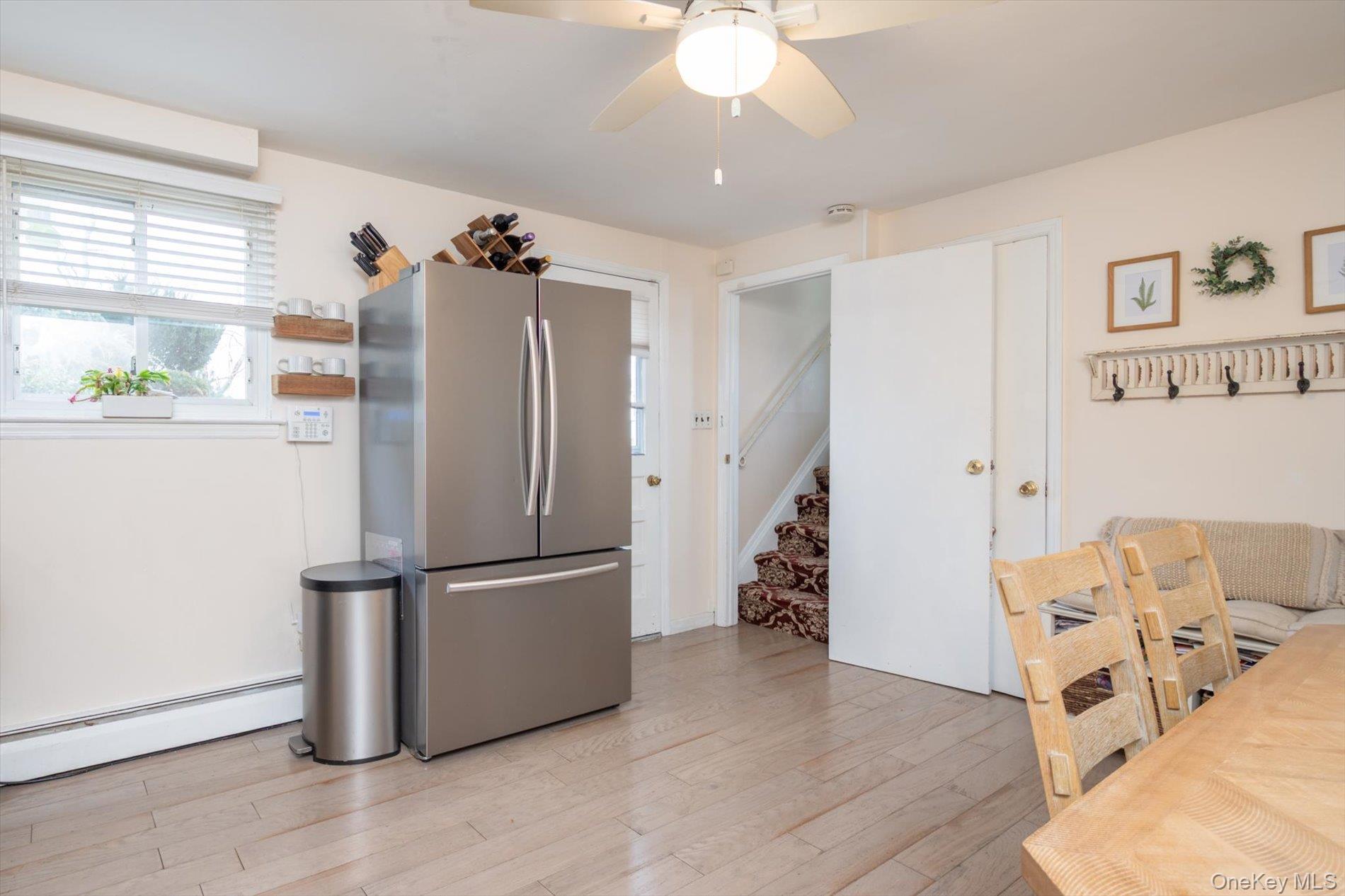 7 Stein Street Valley Stream, NY 11580 - Photo 26 of 27 freestanding refrigerator, a baseboard radiator, light wood-style flooring, and a ceiling fan
