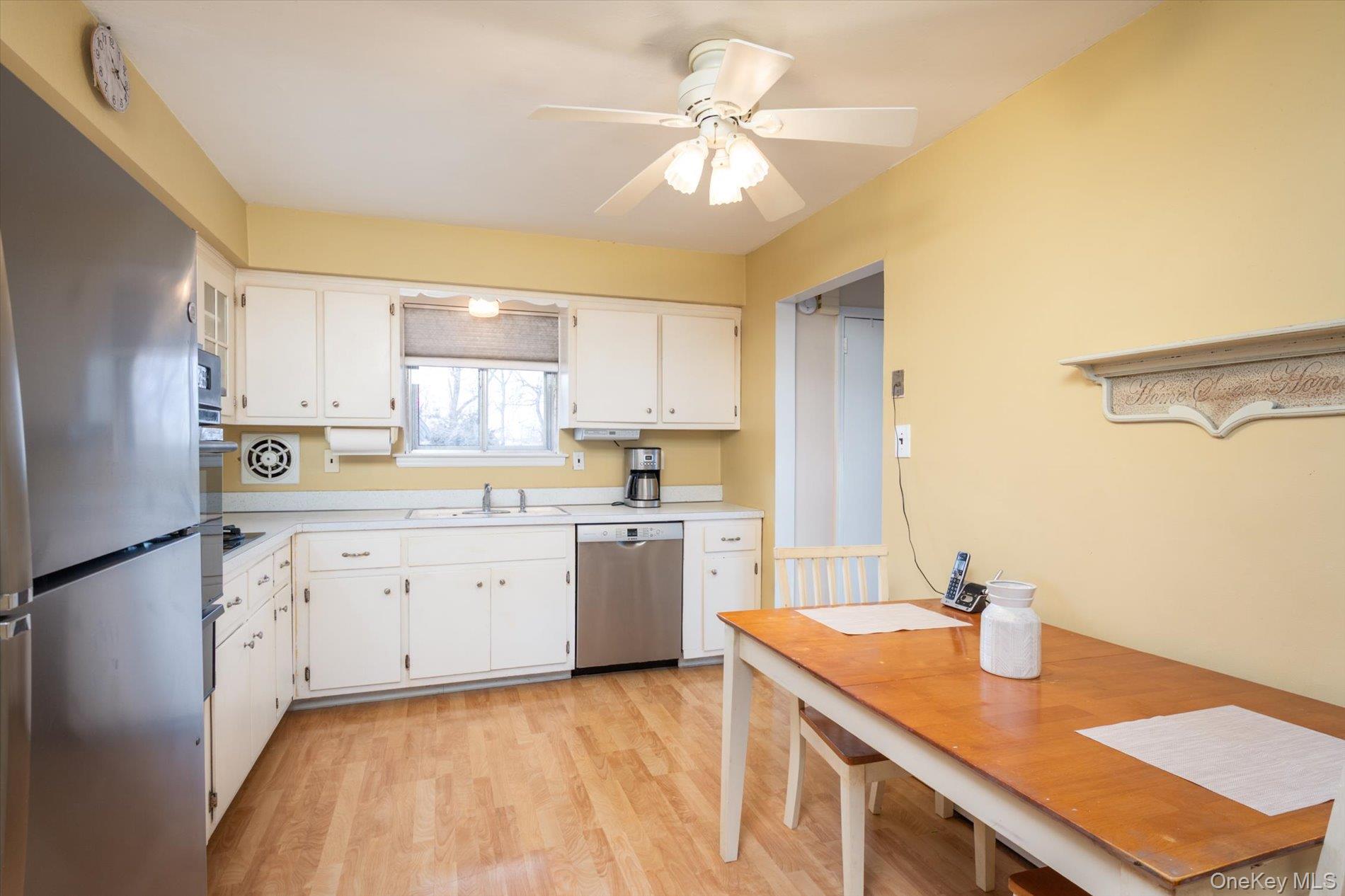 7 Stein Street Valley Stream, NY 11580 - Photo 8 of 27 Kitchen featuring appliances with stainless steel finishes, light countertops, white cabinetry, light wood-type flooring, and ceiling fan