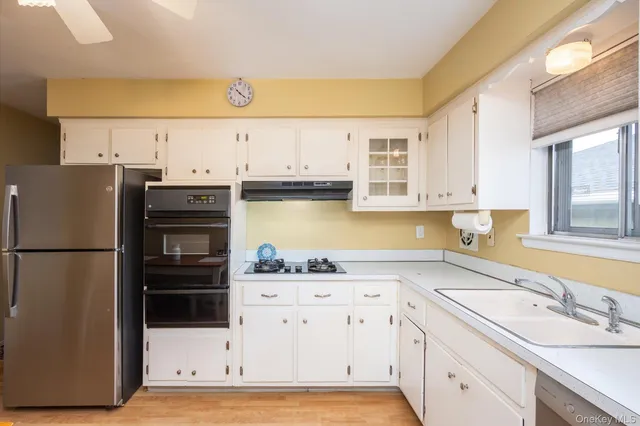a kitchen with stainless steel appliances a refrigerator sink and cabinets