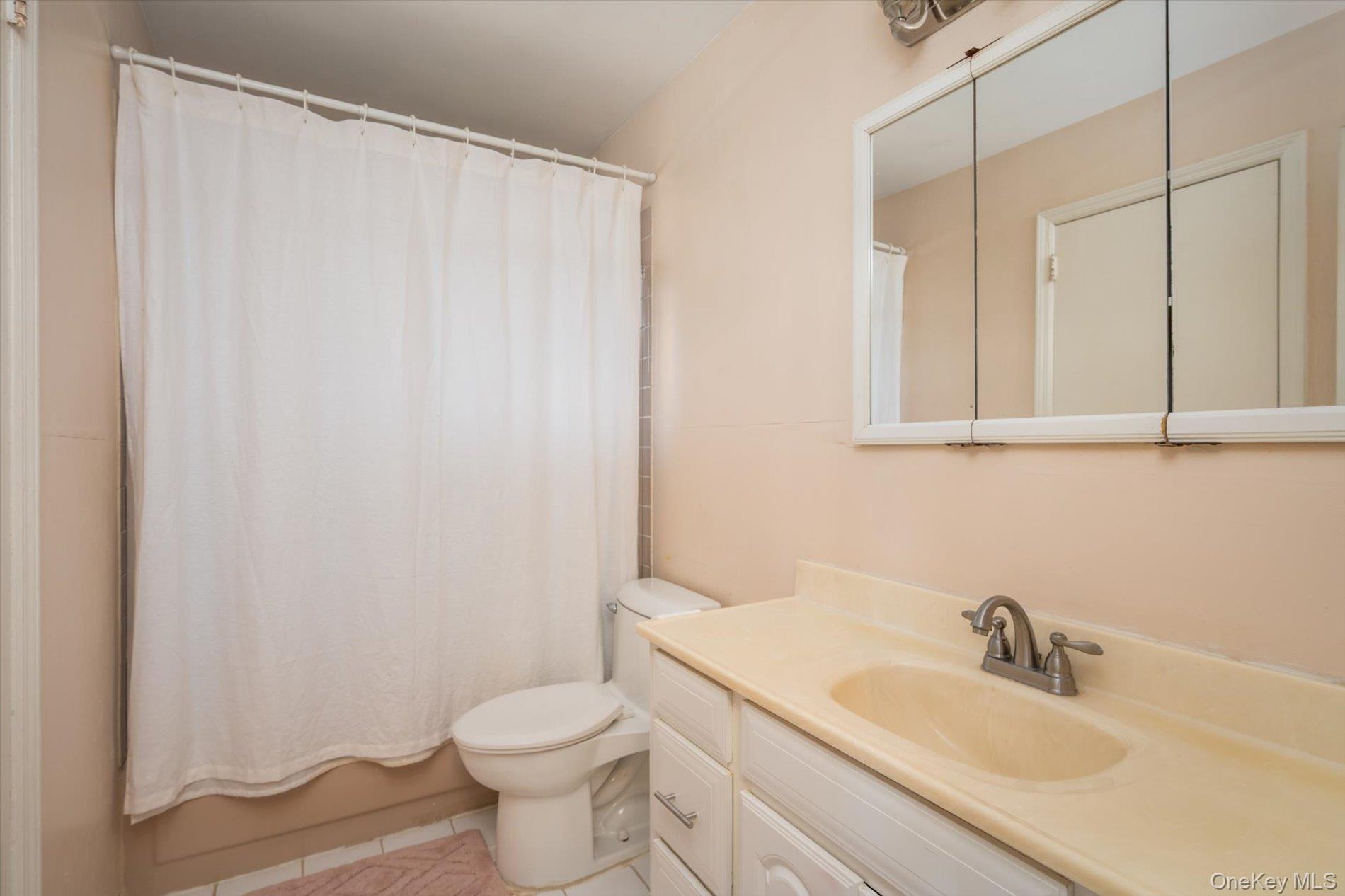 7 Stein Street Valley Stream, NY 11580 - Photo 10 of 27 Bathroom featuring vanity, light tile patterned flooring, and shower / tub combo