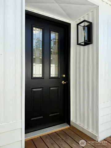 a view of a hallway with wooden floor and a living room