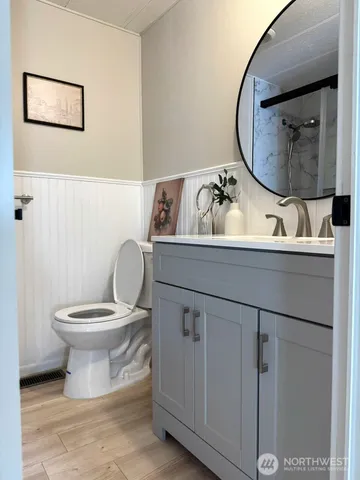 a bathroom with a toilet a sink and mirror
