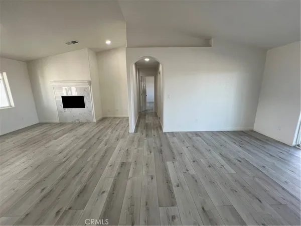 a kitchen with granite countertop a refrigerator a sink and wooden cabinets