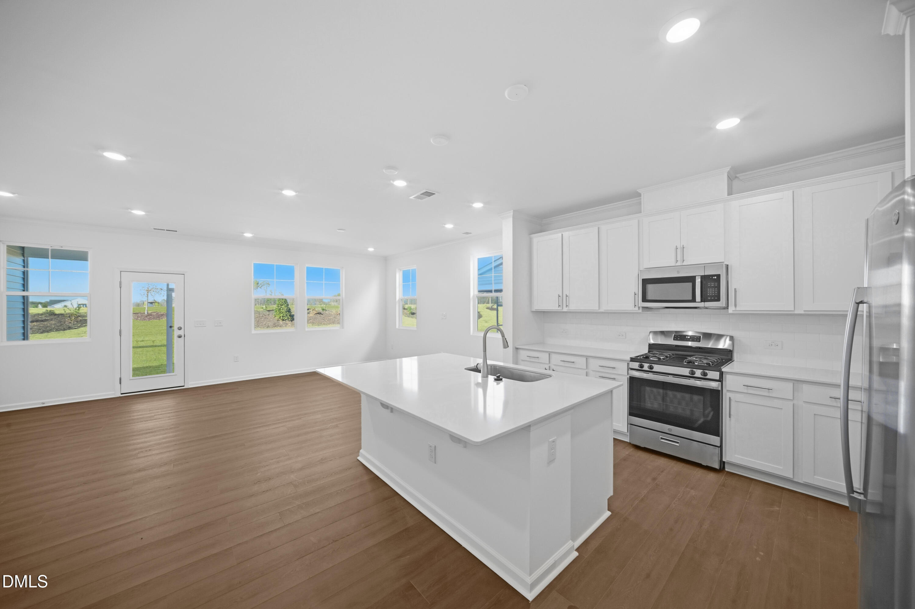 2921 Hickory Fld Drive Raleigh, NC 27616 - Photo 7 of 30 a large kitchen with a center island wooden floor and stainless steel appliances