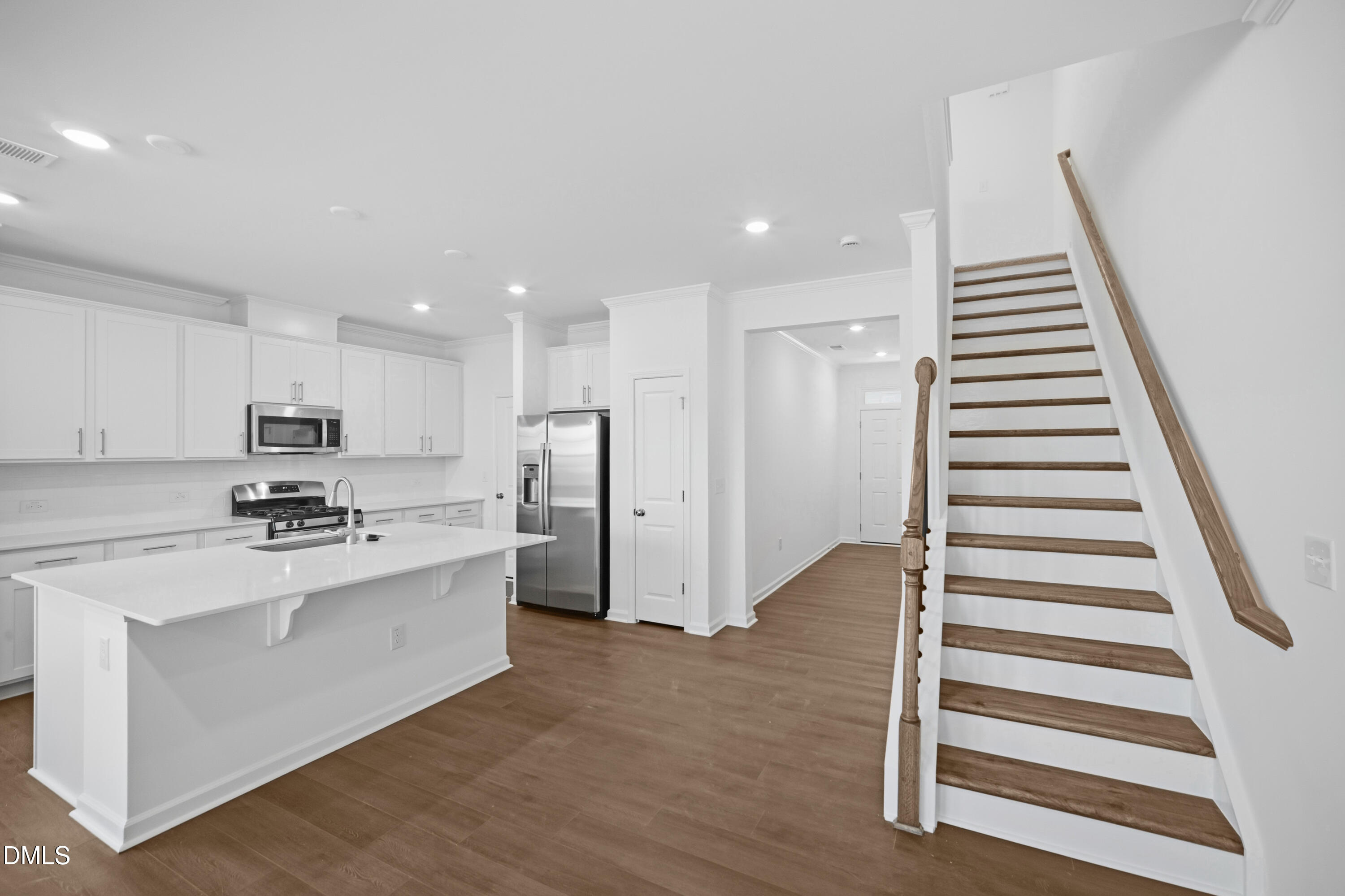 2921 Hickory Fld Drive Raleigh, NC 27616 - Photo 10 of 30 a kitchen with stainless steel appliances kitchen island wooden floor and white cabinets