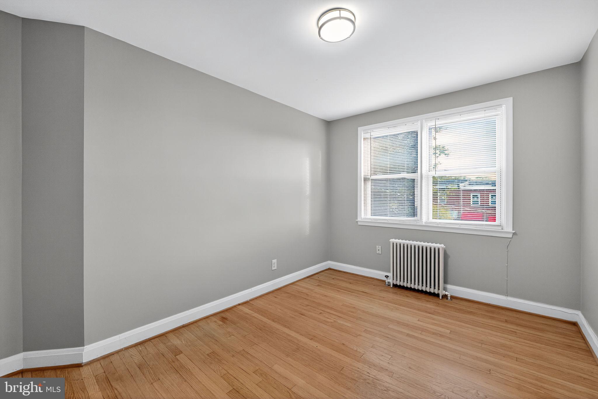 1017 Wicklow Road Baltimore, MD 21229 - Photo 11 of 34 an empty room with wooden floor and windows