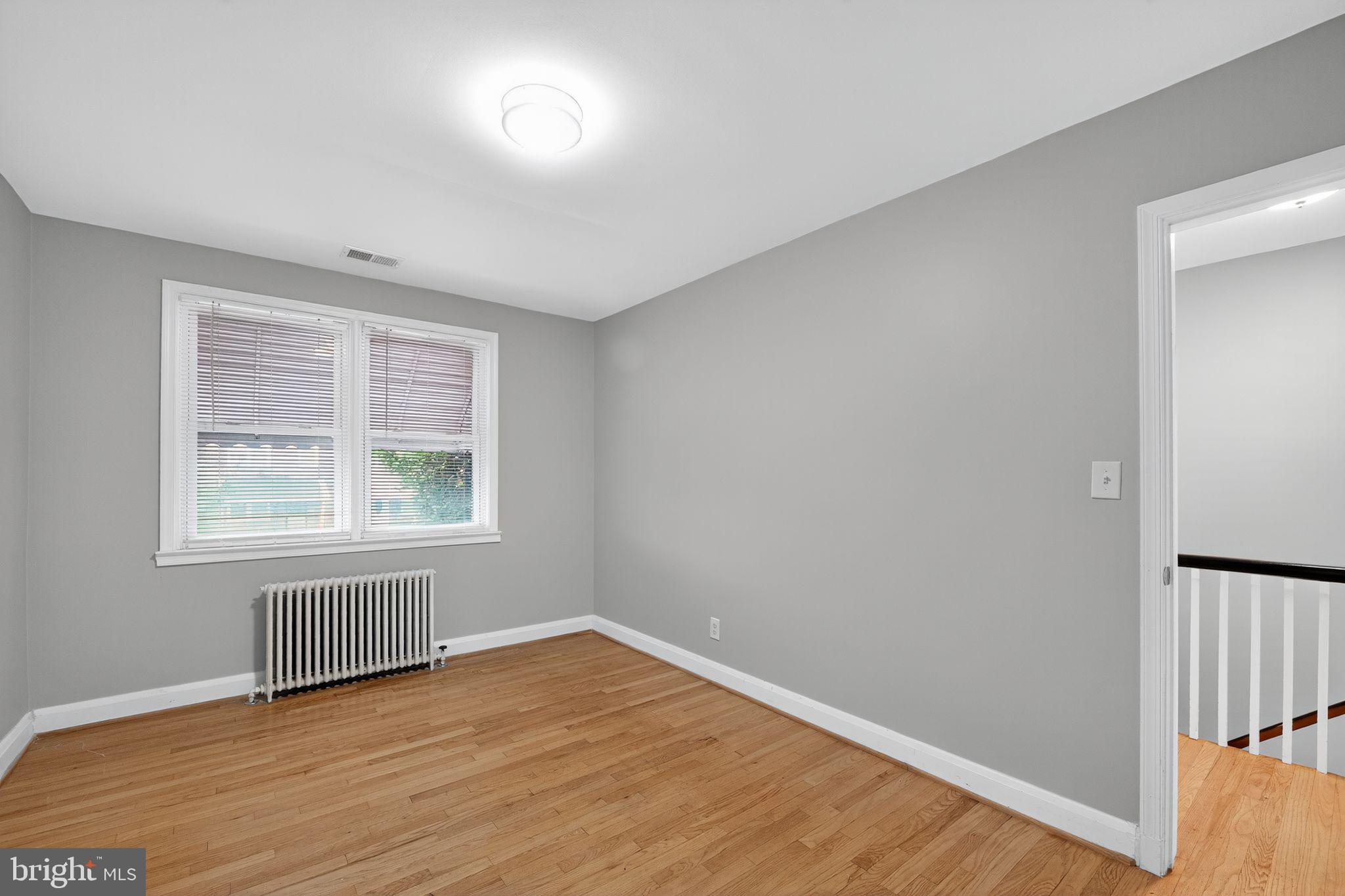 1017 Wicklow Road Baltimore, MD 21229 - Photo 14 of 34 an empty room with wooden floor and windows