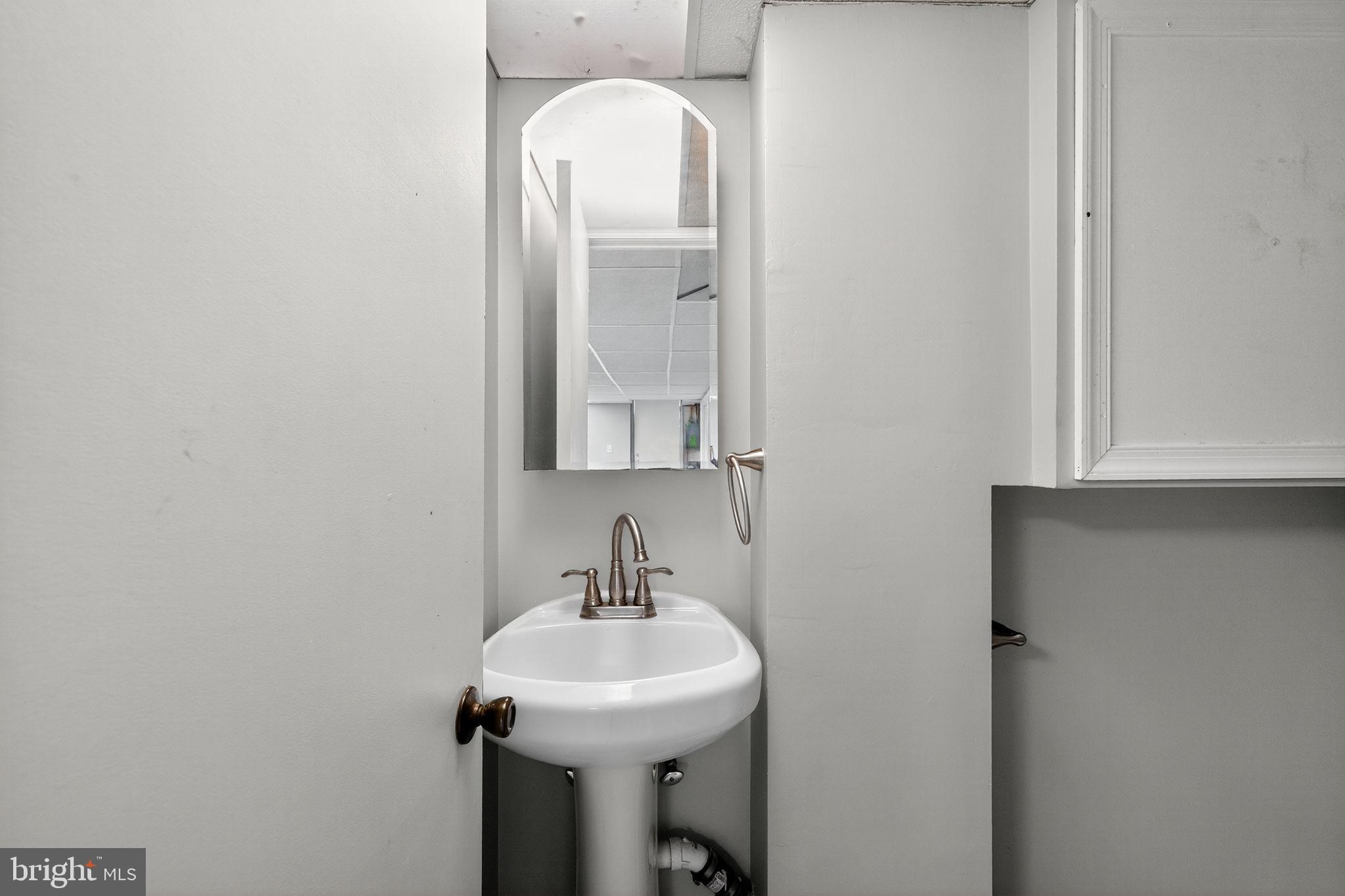 1017 Wicklow Road Baltimore, MD 21229 - Photo 23 of 34 a bathroom with a sink and a mirror