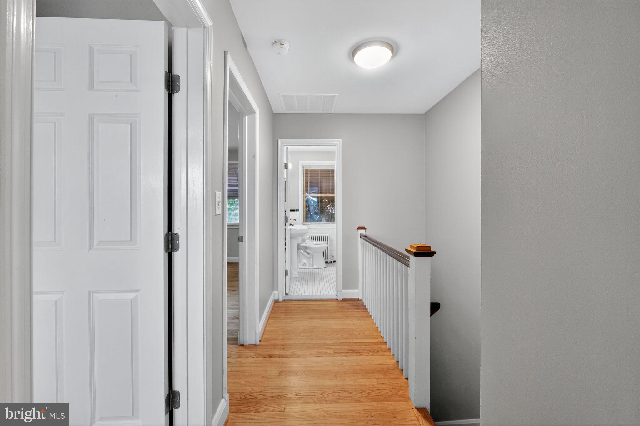 1017 Wicklow Road Baltimore, MD 21229 - Photo 27 of 34 a view of a hallway with wooden floor and a bathroom