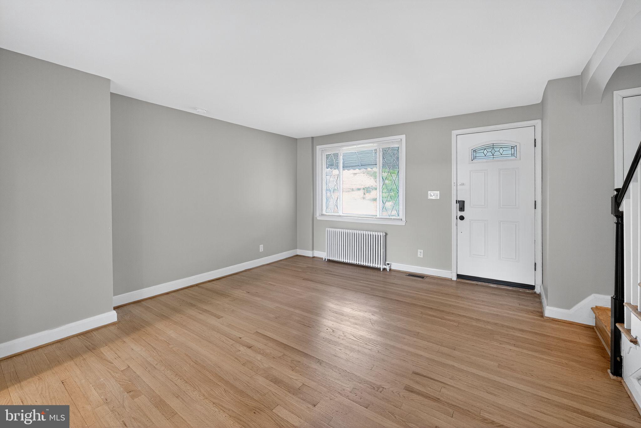1017 Wicklow Road Baltimore, MD 21229 - Photo 5 of 34 an empty room with wooden floor and windows