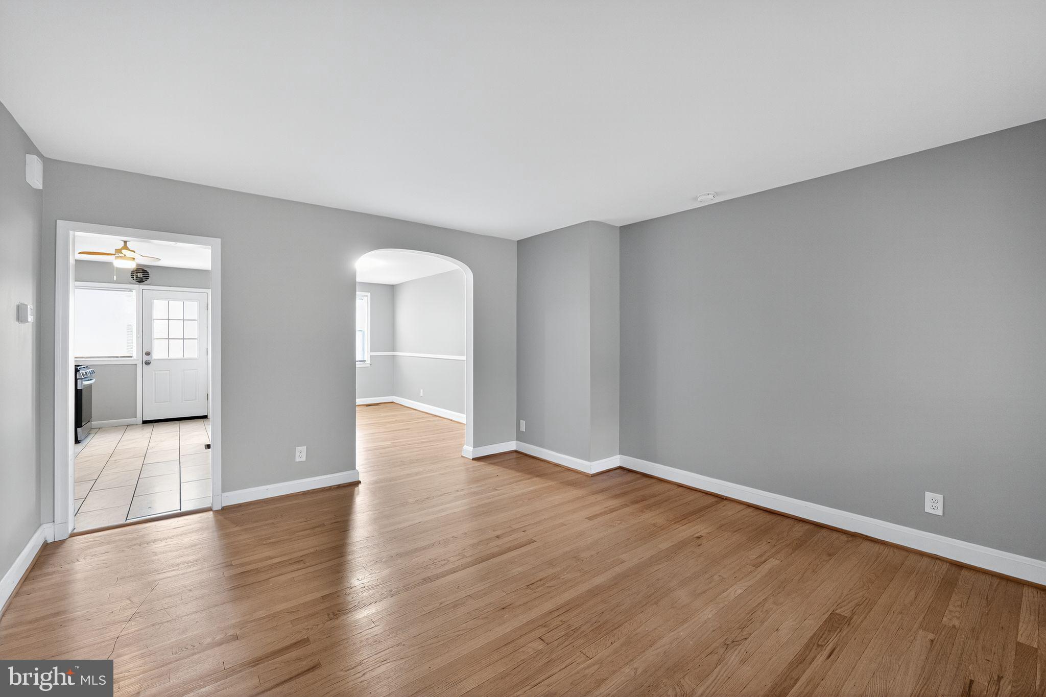 1017 Wicklow Road Baltimore, MD 21229 - Photo 6 of 34 a view of an empty room with wooden floor and a window