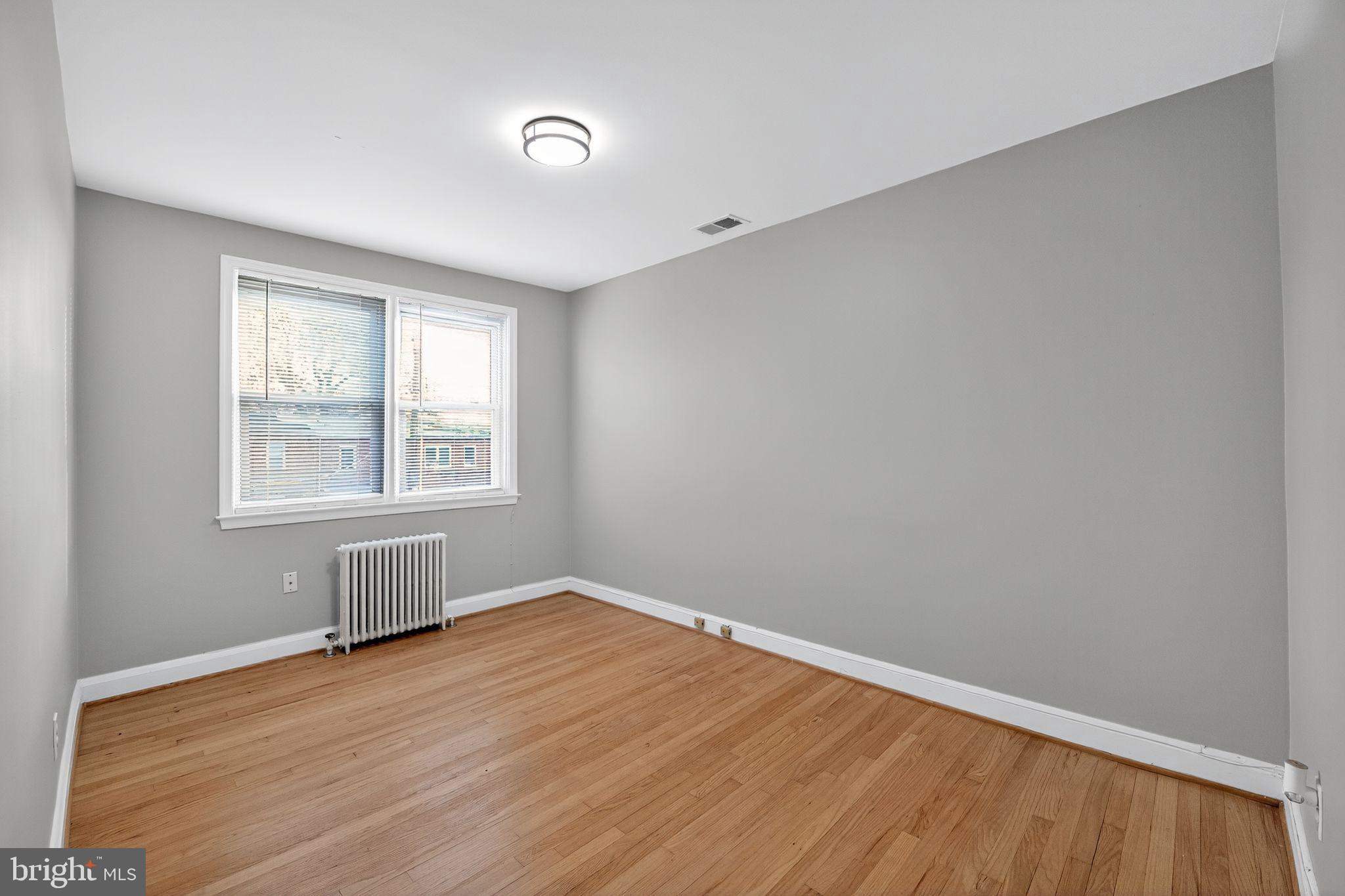 1017 Wicklow Road Baltimore, MD 21229 - Photo 8 of 34 an empty room with wooden floor and windows