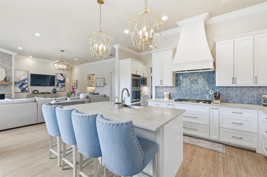 476 Hidden Valley Lane Coppell, TX 75019 - Photo 7 of 40 a large kitchen with granite countertop a stove a sink a dining table and chairs