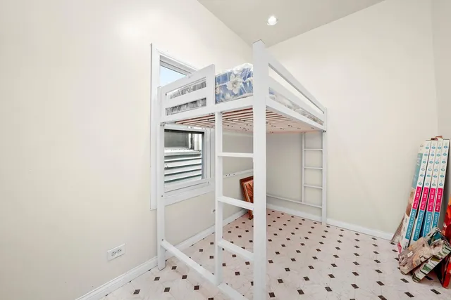 a bed sitting in a bedroom next to a window