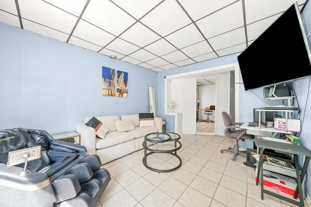 a living room with furniture a flat screen tv and a table