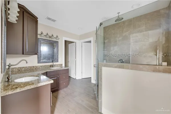 a bathroom with a granite countertop sink mirror and a bathtub