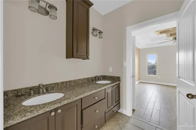 a bathroom with a granite countertop sink and a mirror