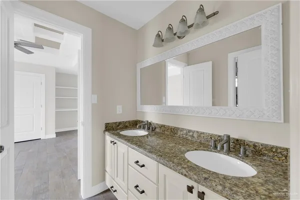 a bathroom with a granite countertop sink and a mirror