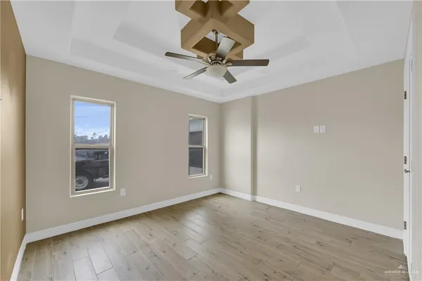 a view of a room with wooden floor ceiling fan and window