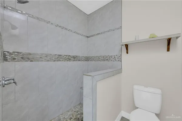 a white toilet sitting next to a shower