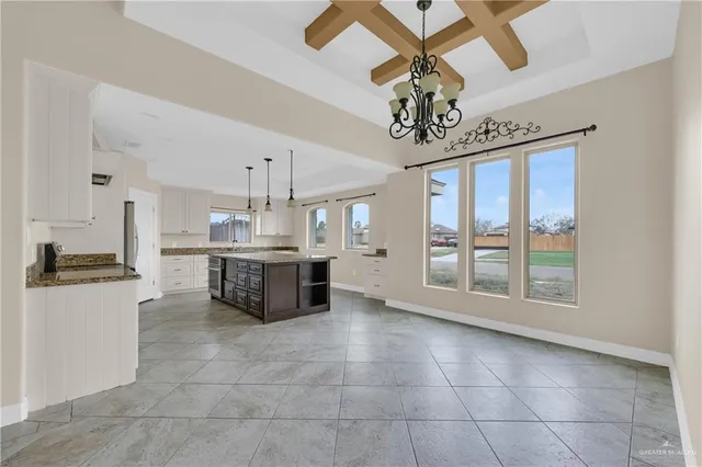 a kitchen with kitchen island granite countertop a stove top oven a sink a counter top space and cabinets