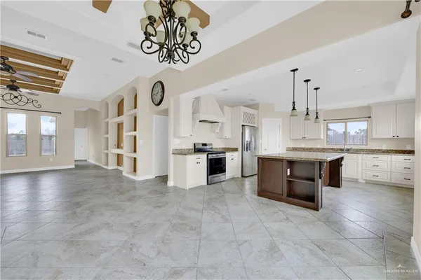a large white kitchen with a refrigerator a stove a sink and a cabinets