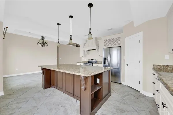 a kitchen with kitchen island a sink stove and refrigerator