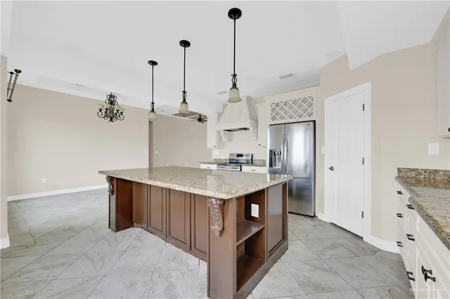 a kitchen with kitchen island a sink stove and refrigerator
