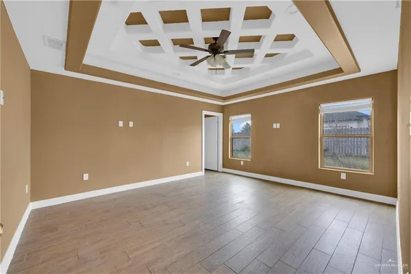 an empty room with wooden floor and white walls
