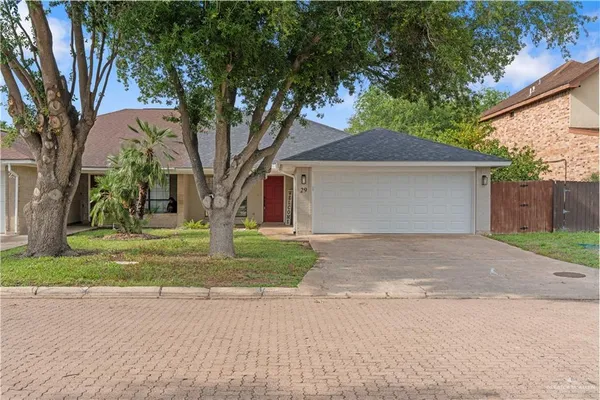 a front view of a house with a yard and an trees