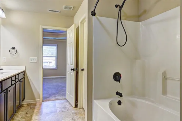a bathroom with a tub a sink and a shower