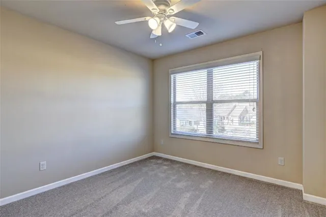 an empty room with a window and a fan