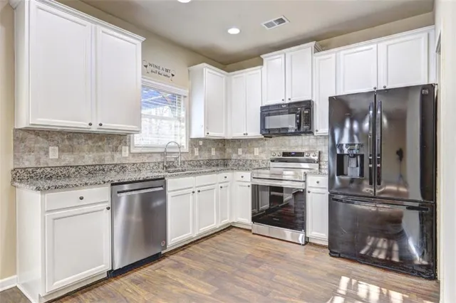 a kitchen with stainless steel appliances granite countertop a stove a sink and a refrigerator