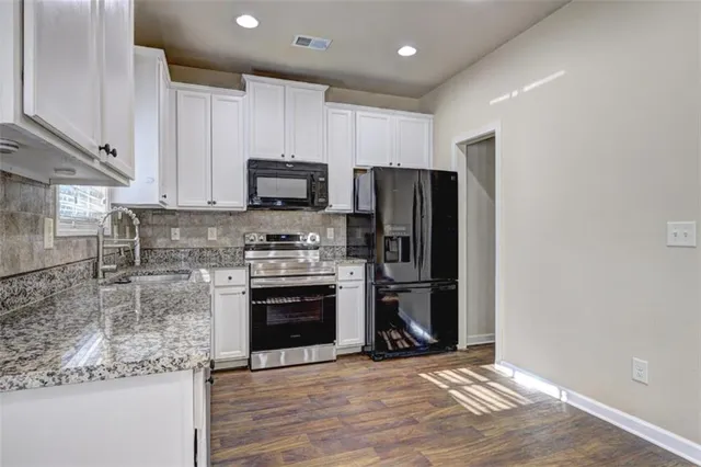 a kitchen with stainless steel appliances granite countertop a refrigerator stove and microwave