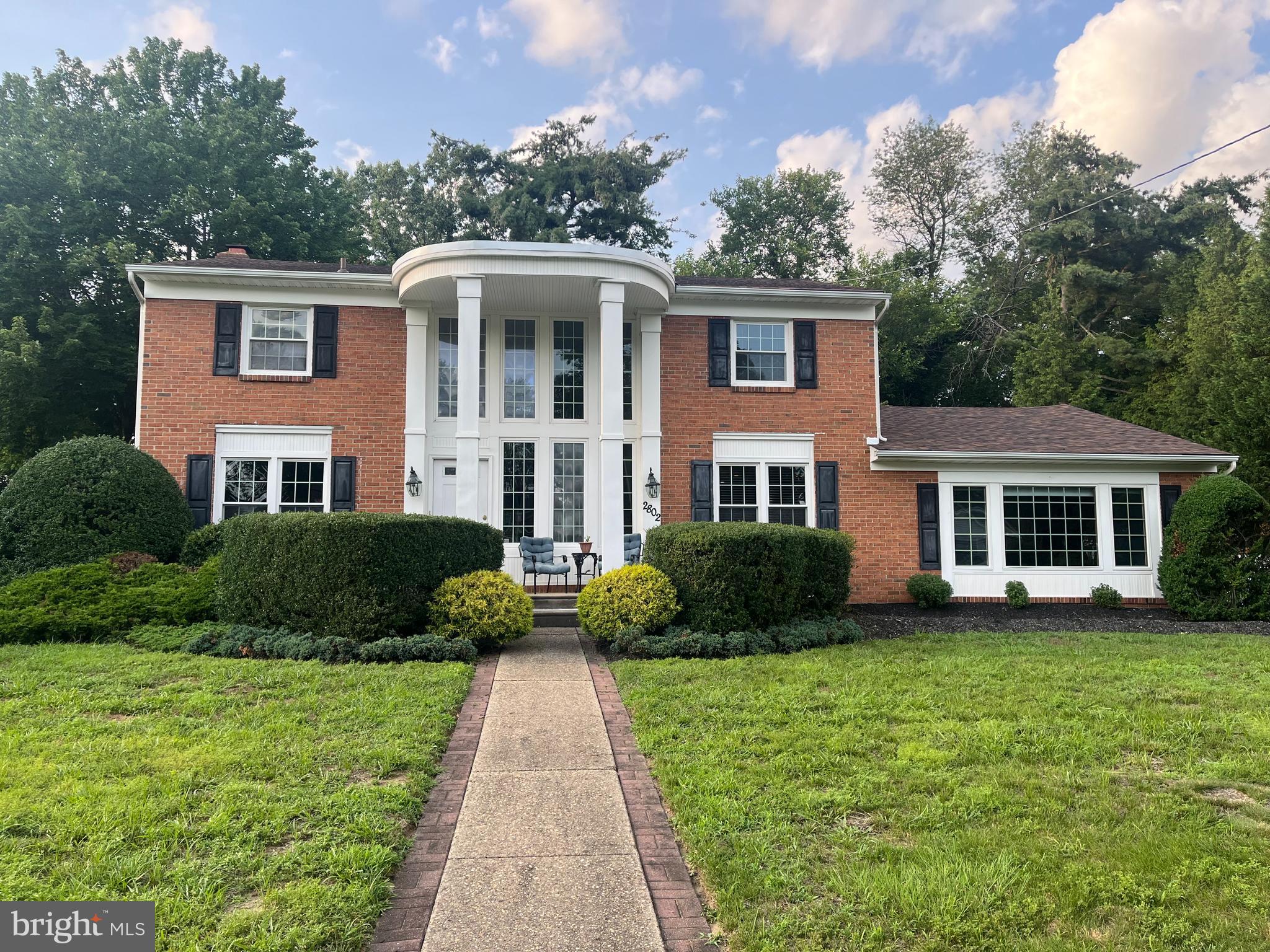 a front view of a house with a yard and trees
