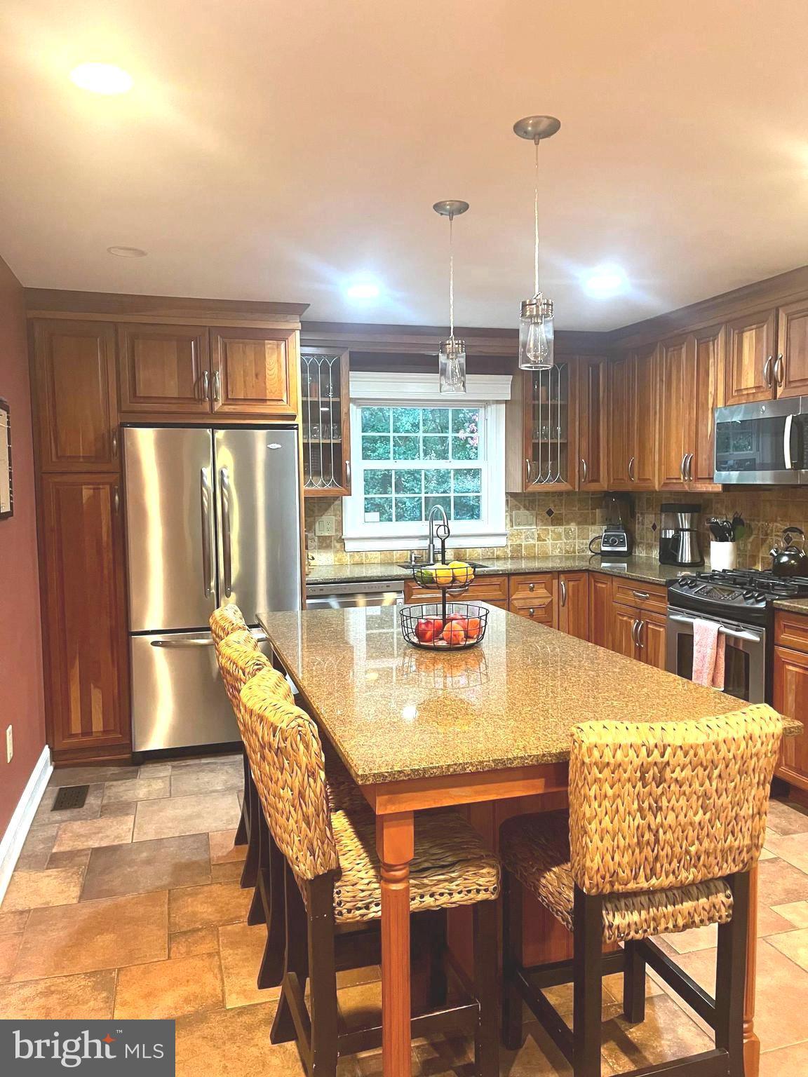 2802 Waterford Drive Cinnaminson, NJ 08077 - Photo 17 of 59 a kitchen with stainless steel appliances granite countertop a stove top oven a dining table and chairs with wooden floor