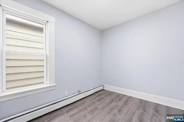 a view of a small space with wooden floor and a window