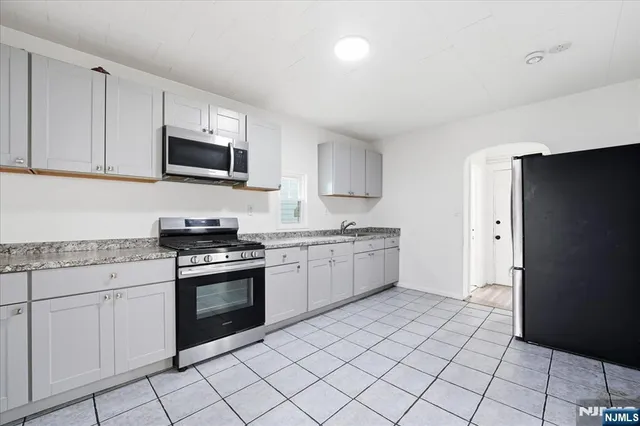 a kitchen with stainless steel appliances granite countertop a refrigerator and a stove top oven