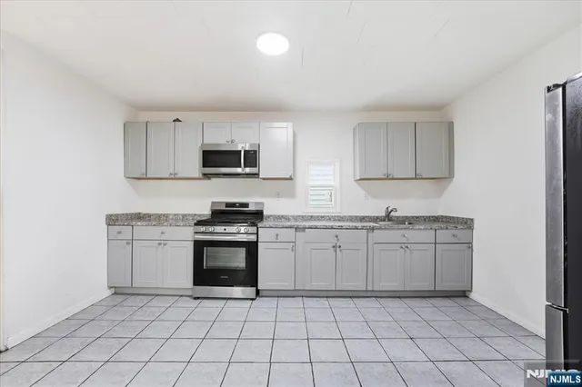 a kitchen with granite countertop a sink and a stove top oven