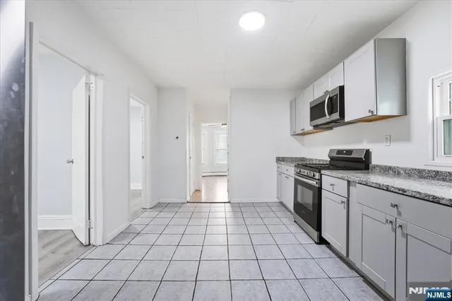 a kitchen with stainless steel appliances granite countertop a refrigerator and a stove
