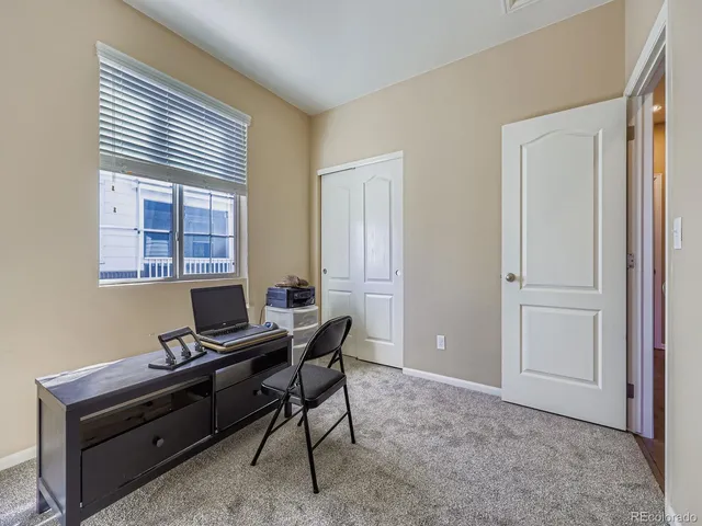a view of a workspace with furniture and a window