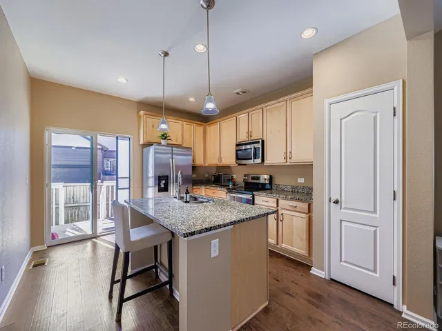 a kitchen with stainless steel appliances granite countertop a stove refrigerator and microwave