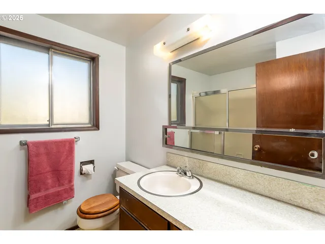 a bathroom with a sink a toilet and mirror