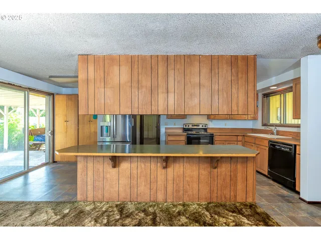 a kitchen with kitchen island granite countertop a stove a sink and a microwave