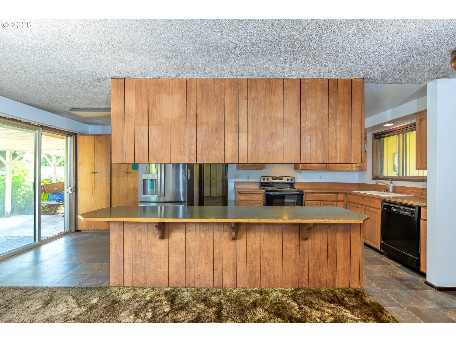 47711 Commercial Street Oakridge, OR 97463 - Photo 5 of 32 a kitchen with kitchen island granite countertop a stove a sink and a microwave