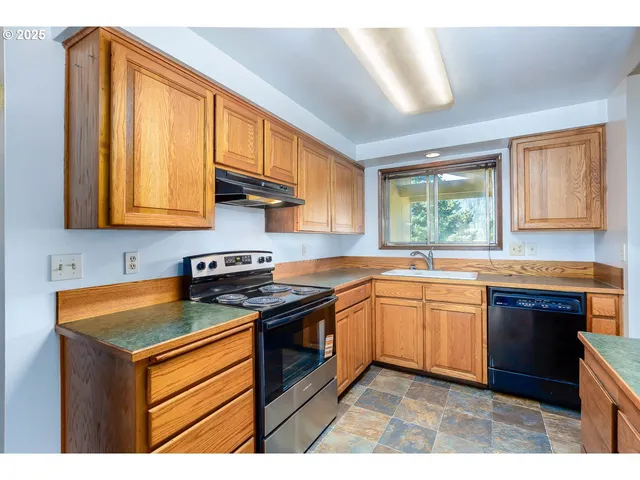 a kitchen with stainless steel appliances granite countertop a stove sink and cabinets