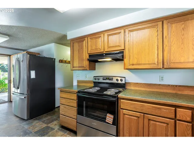 a kitchen with stainless steel appliances granite countertop a stove a refrigerator and a microwave